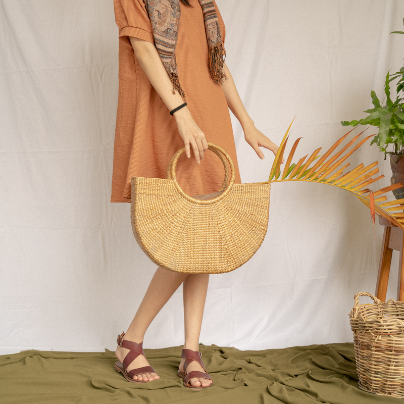 Young Woman in Brown Dress Holding Native Rattan Bag